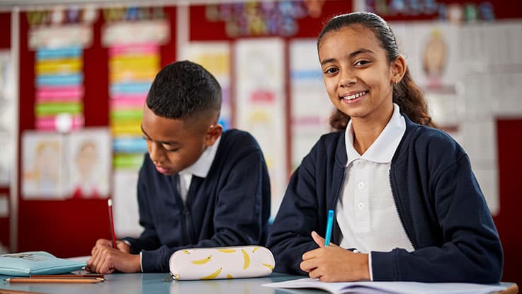 girl at school desk smiling