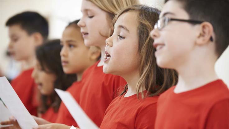 children-standing-in-raw-wearing-red-t-shirt