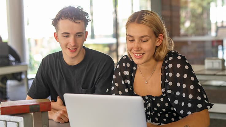 two people man and woman sitting at computer