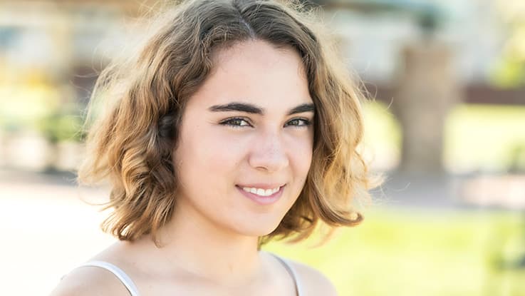 young girl with blonde hair looking directly at camera