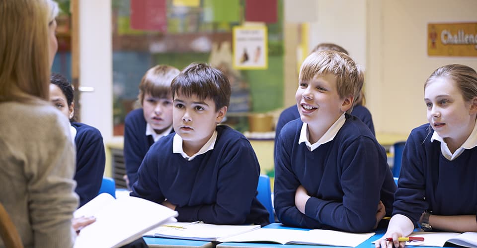 students sitting in classroom listing to teacher